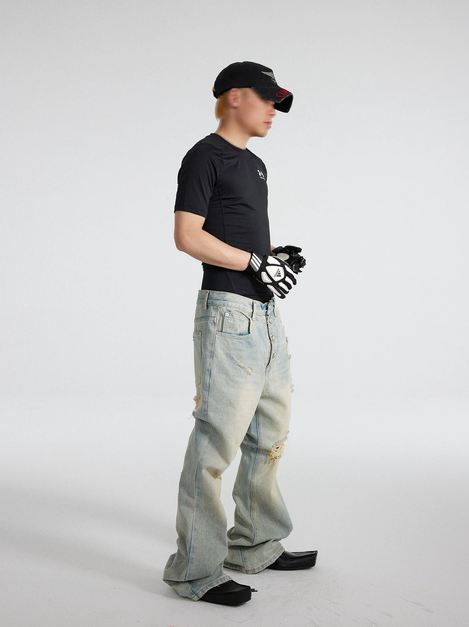 Men's distressed vintage blue sunfade flare jeans shown in a right side full-body studio view, featuring a relaxed thigh, ripped knee details, faded denim wash, and stacked wide hem