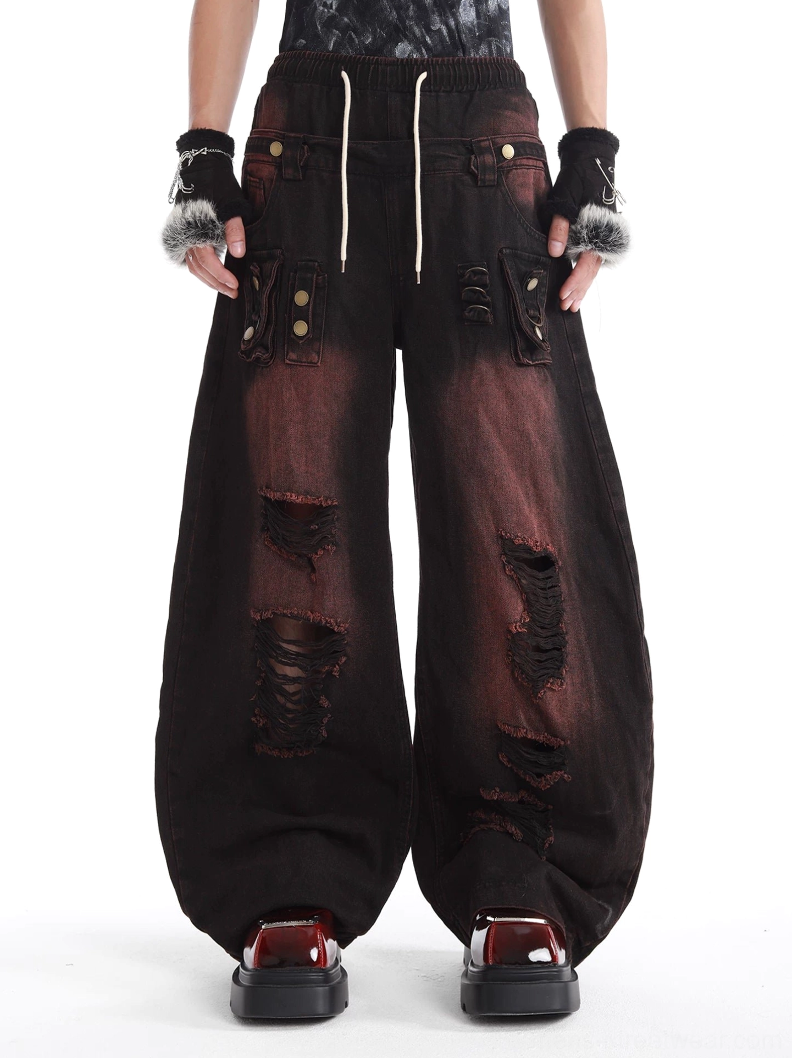 Front view of distressed two-tone wide-leg cargo denim pants with ripped details oversized utility pockets and drawstring waist