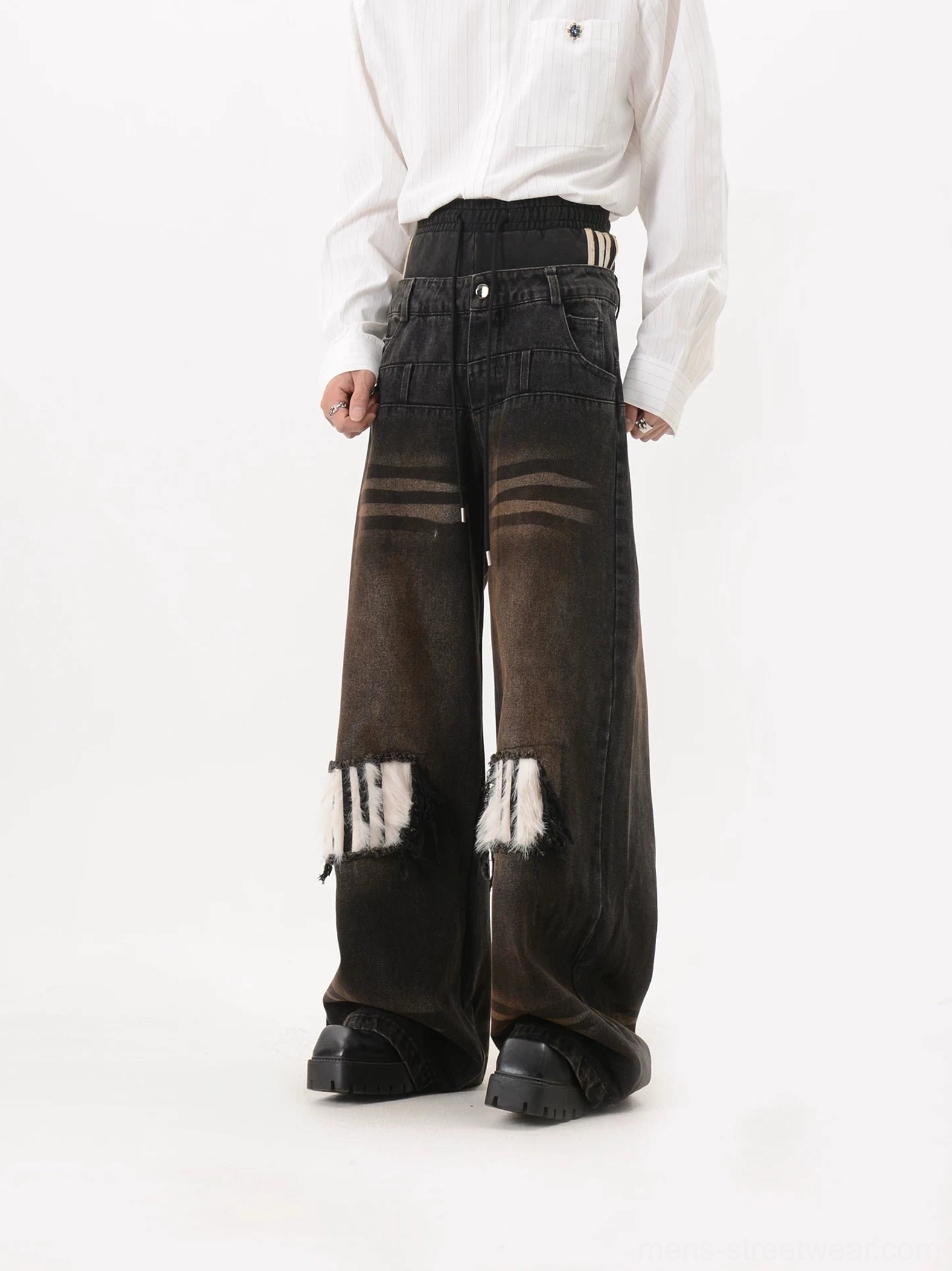 Front right three quarter view of distressed washed black wide leg jeans with frayed faux fur knee panels, button closure and oversized streetwear silhouette