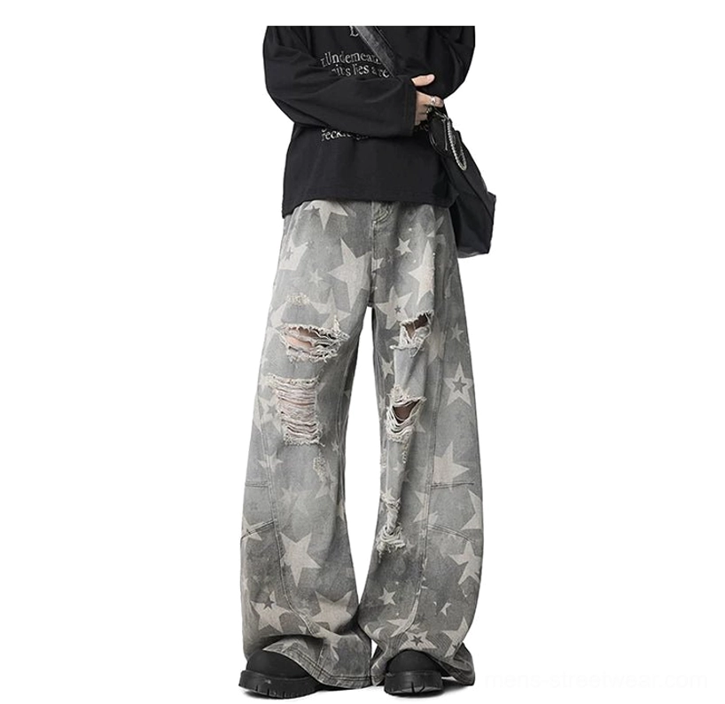 Distressed washed grey star print wide leg jeans front three quarter view with frayed knee rips