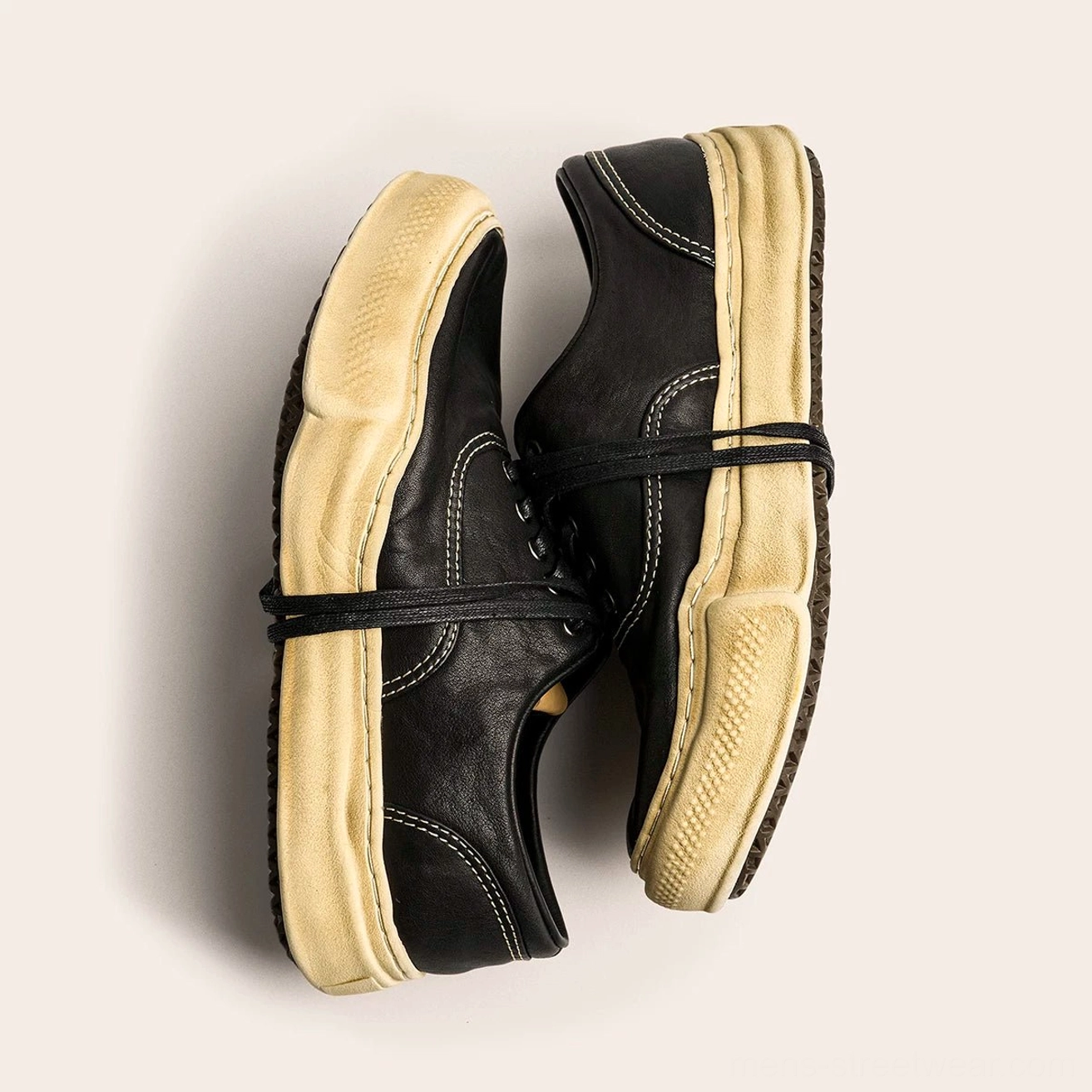 Distressed washed leather retro sneakers presented as a detailed product image for streetwear styling with thick dissolved soles and lace-up uppers