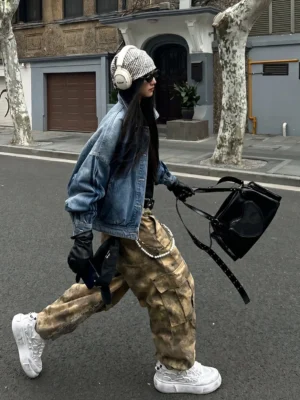 Distressed white panda platform sneakers styled with denim jacket and camouflage cargo pants in an urban streetwear outfit