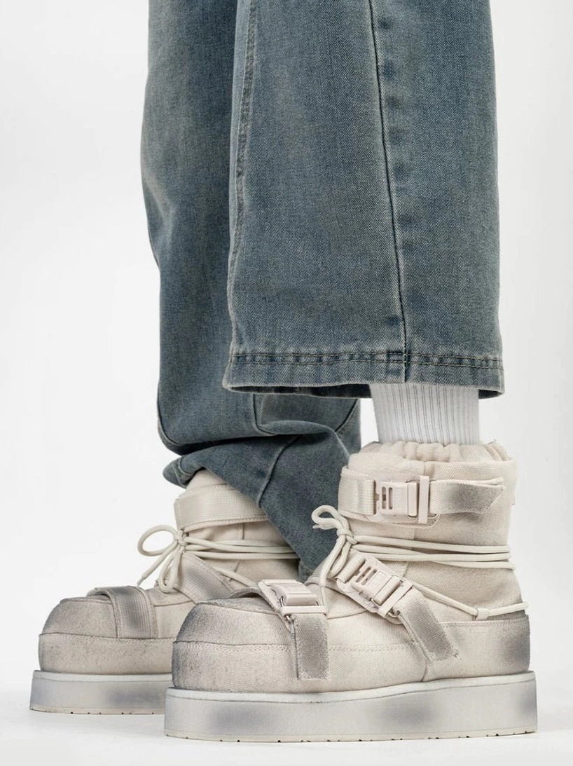Distressed white triple-buckle platform winter boots worn with loose blue jeans, featuring fleece collar and lace-up front