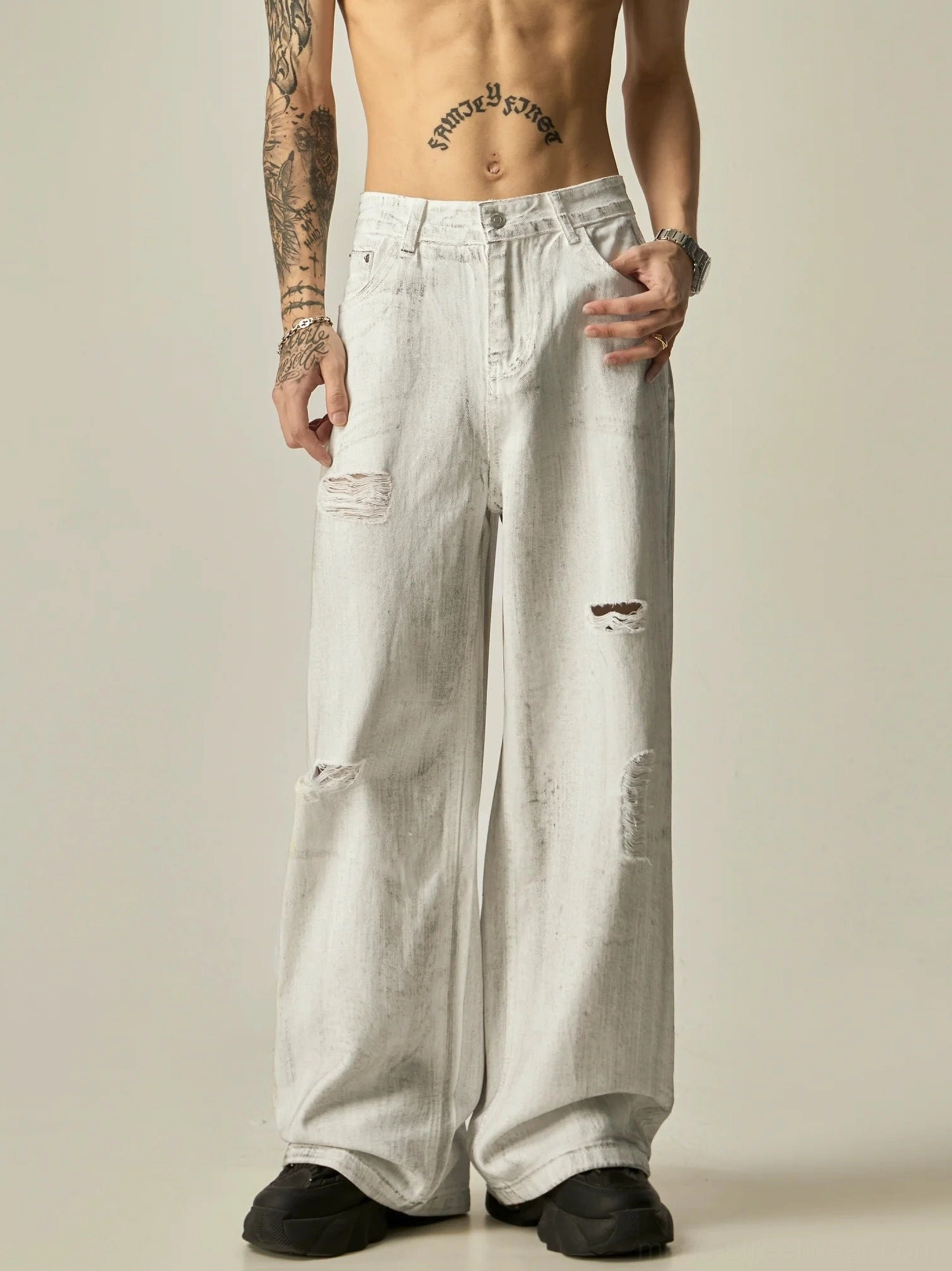 Front full-body view of distressed white wide-leg acid wash denim jeans with ripped details