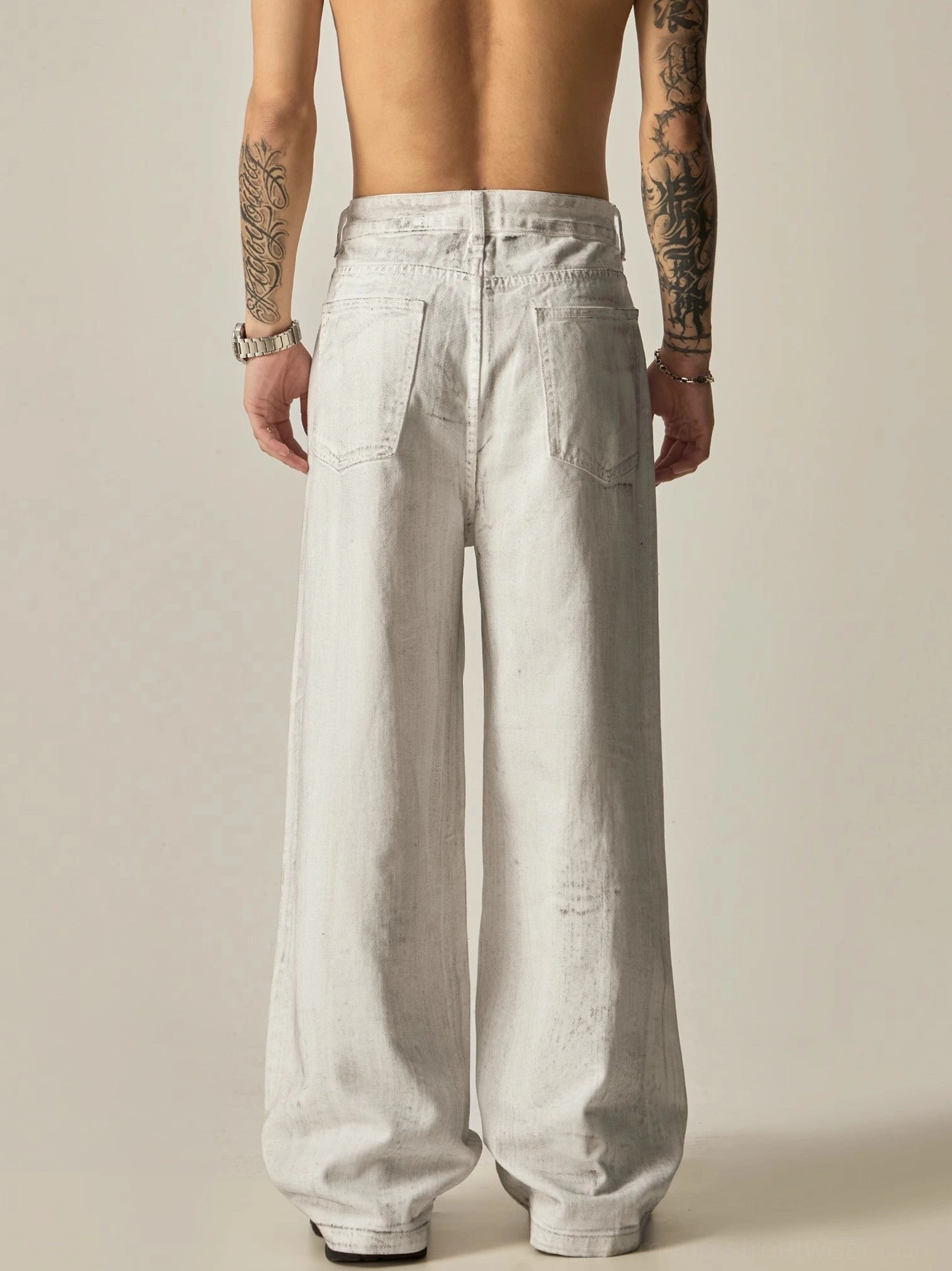 Back view of faded off-white wide-leg distressed denim jeans with classic rear pockets