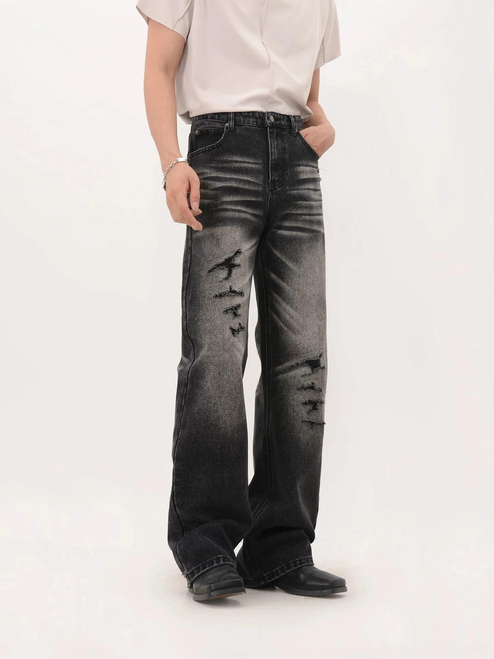 Faded black wide-leg distressed denim jeans three-quarter side view showing relaxed streetwear fit