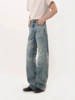 Vintage blue distressed wide-leg denim jeans front angled view with ripped knees and faded whiskering