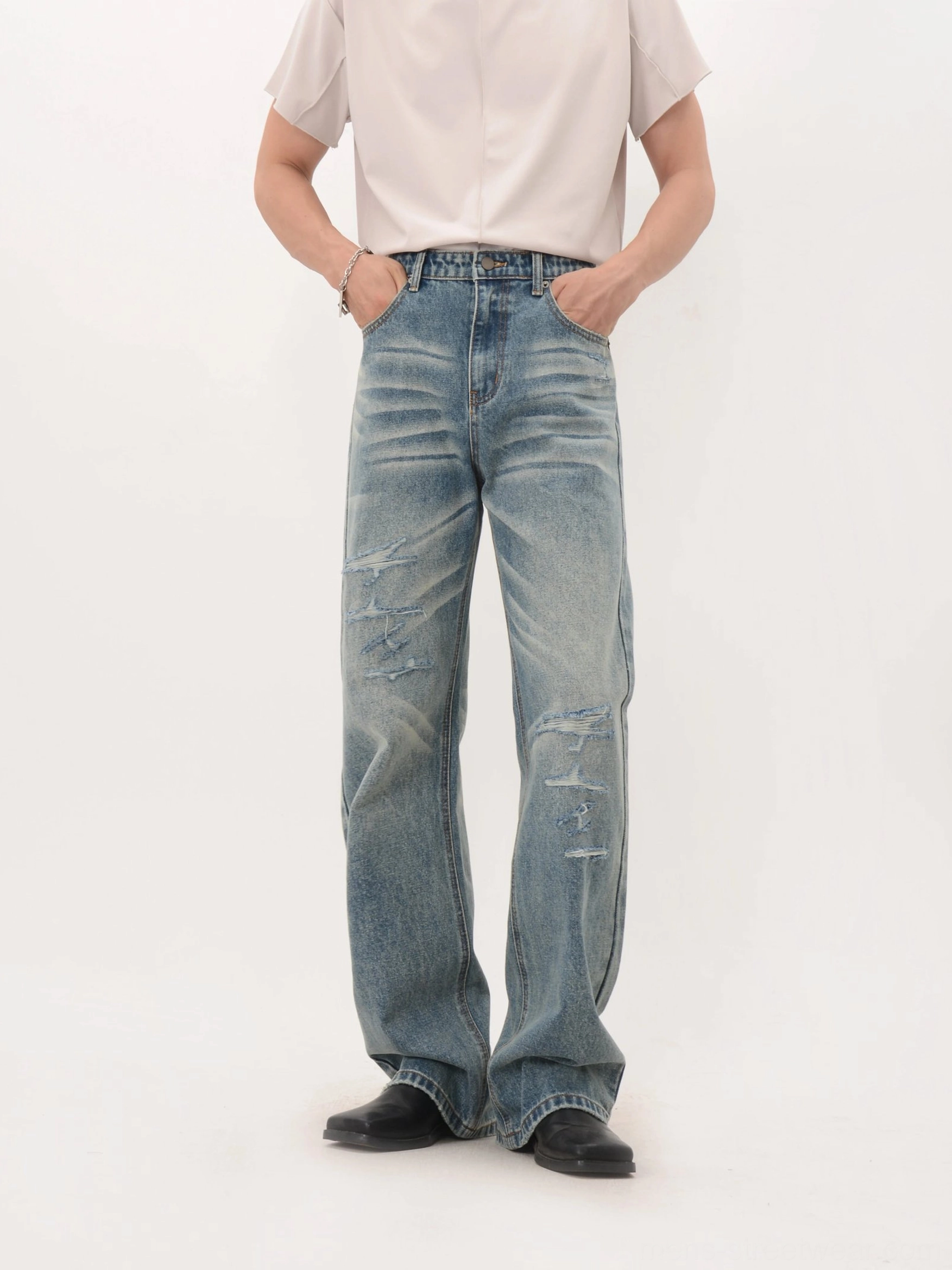 Vintage blue distressed wide-leg jeans with whiskering ripped legs and loose full-length drape