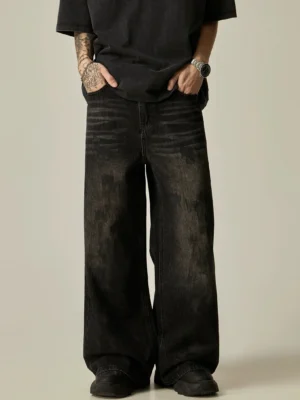 Faded black distressed wide-leg denim jeans worn with an oversized black T-shirt in front full-body studio view