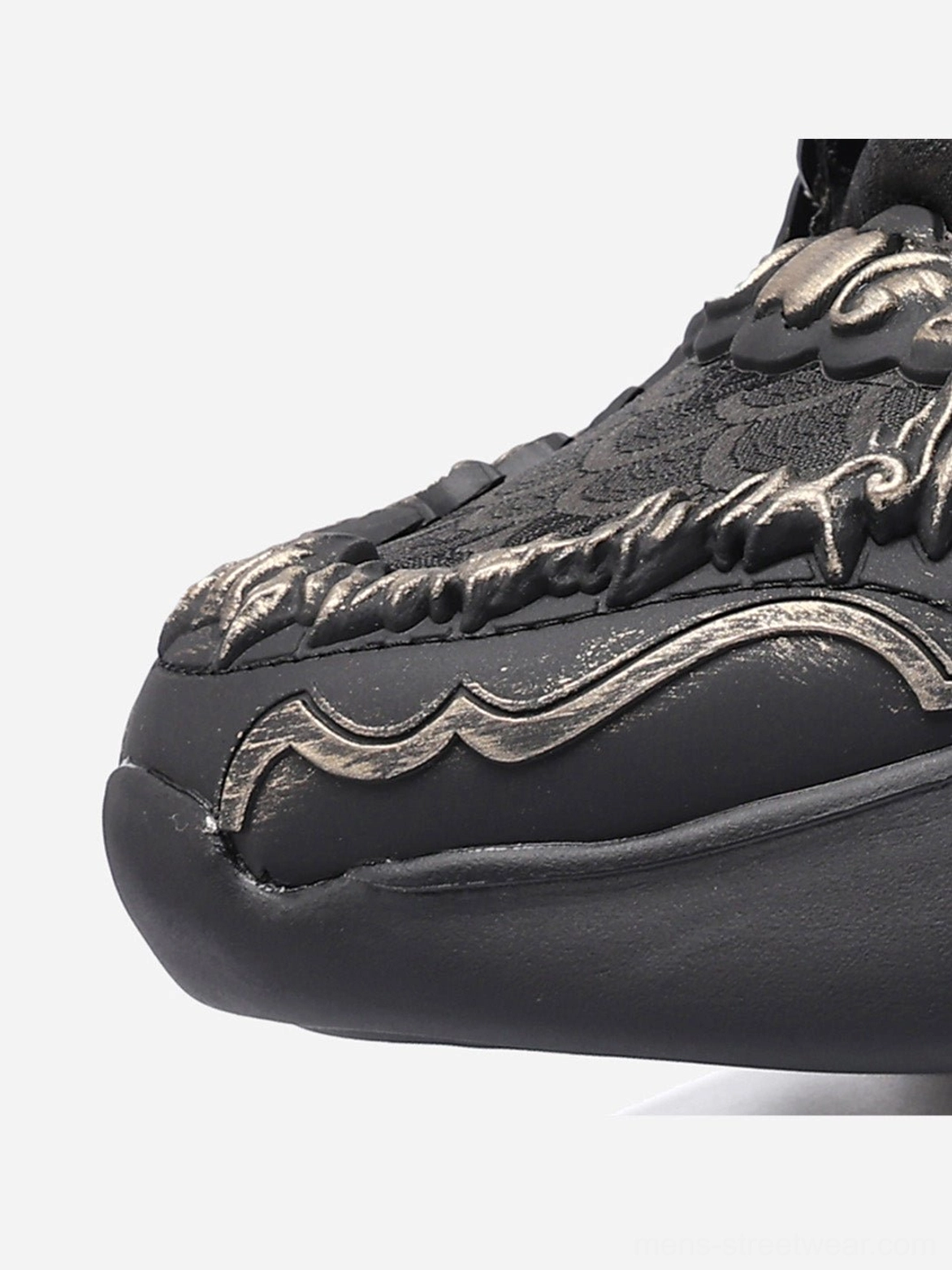 Dragon crest chunky runner sneakers black colorway featuring dimensional dragon motif scale heel texture and oversized sole