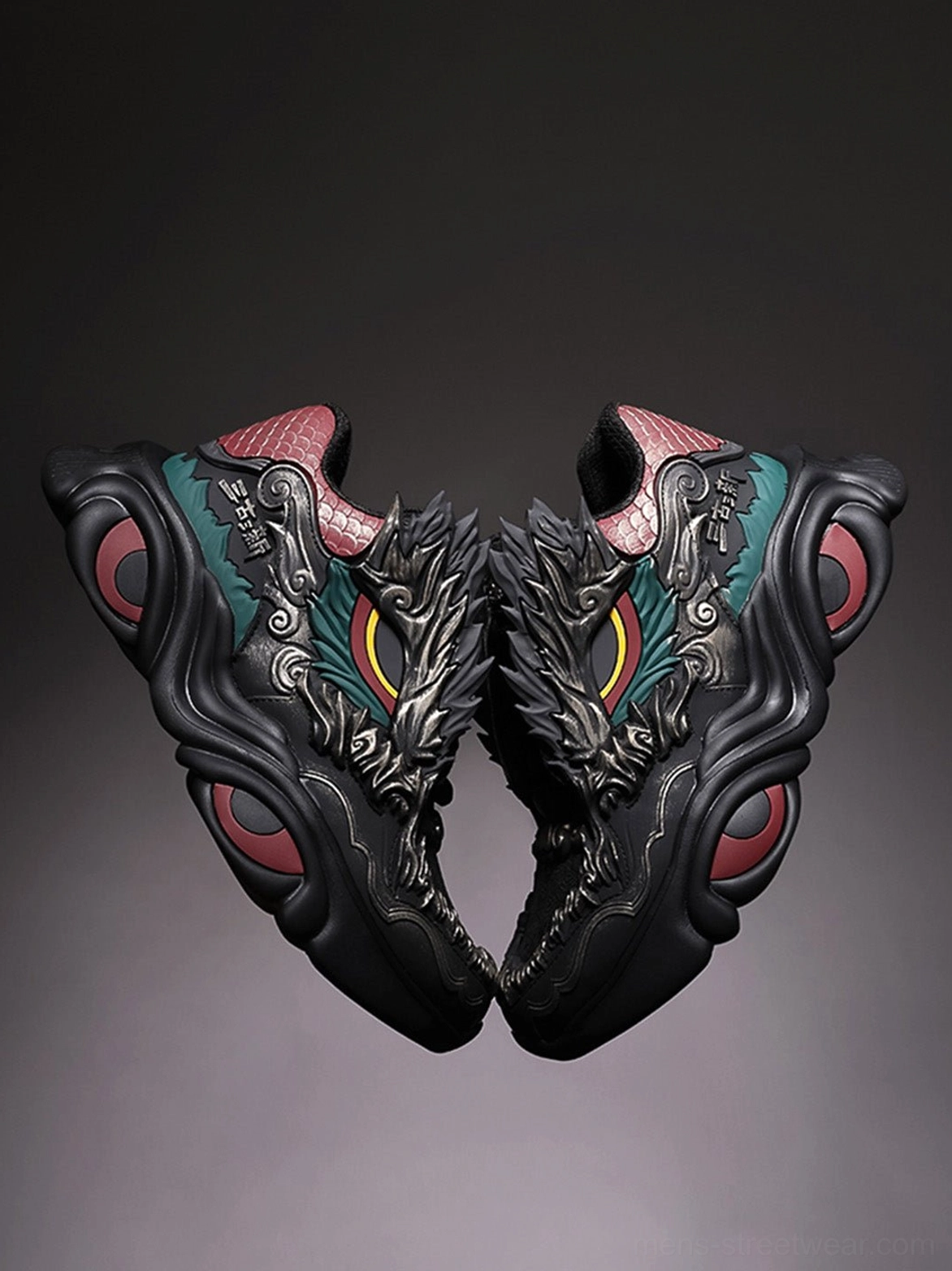 Rear angled pair of black dragon themed chunky sneakers with scale textured heel tabs red circular sole accents and sculpted outsoles