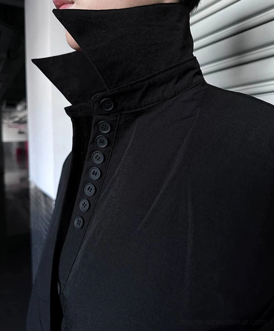 Close-up view of solid black oversized cuff shirt with stand-up folded collar and vertical button row