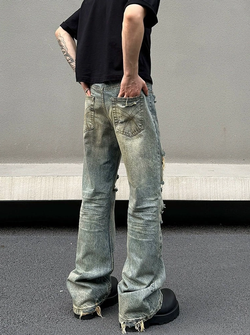 Back view of vintage washed blue distressed flared jeans with five pocket construction and frayed hems