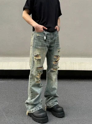 Front low angle view of blue distressed flared jeans with shredded rips raw frayed hems and platform boots