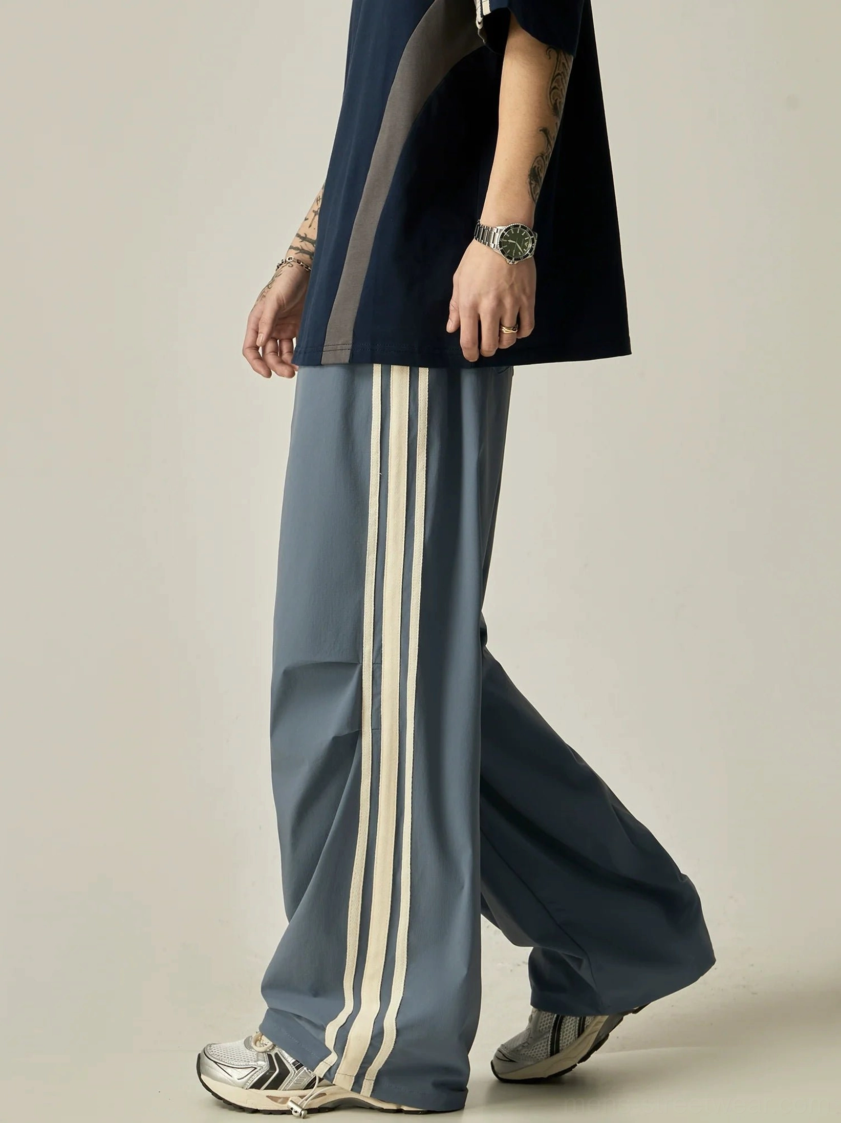 Dusty blue Korean streetwear wide-leg triple stripe athletic pants in a walking pose with relaxed flowing silhouette