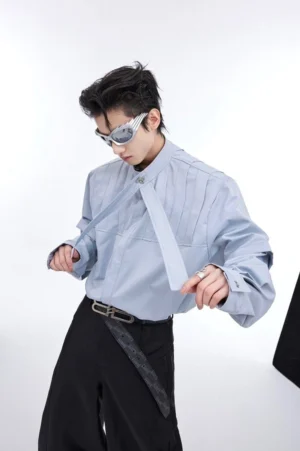 Dusty blue pleated stand collar oversized long sleeve shirt with neck tie detail and buttoned cuff close-up