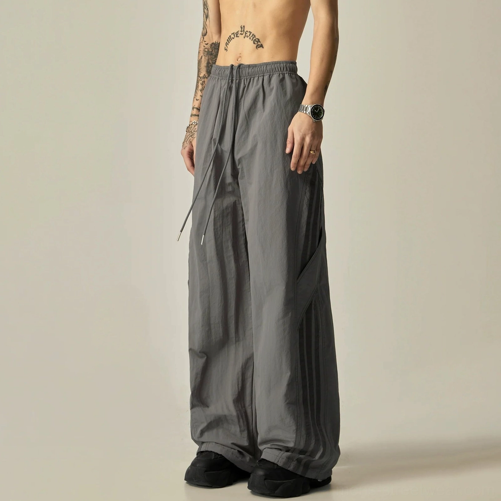 Dusty gray wide-leg athletic pants in a front three-quarter studio view with elastic drawstring waist and relaxed Korean streetwear silhouette