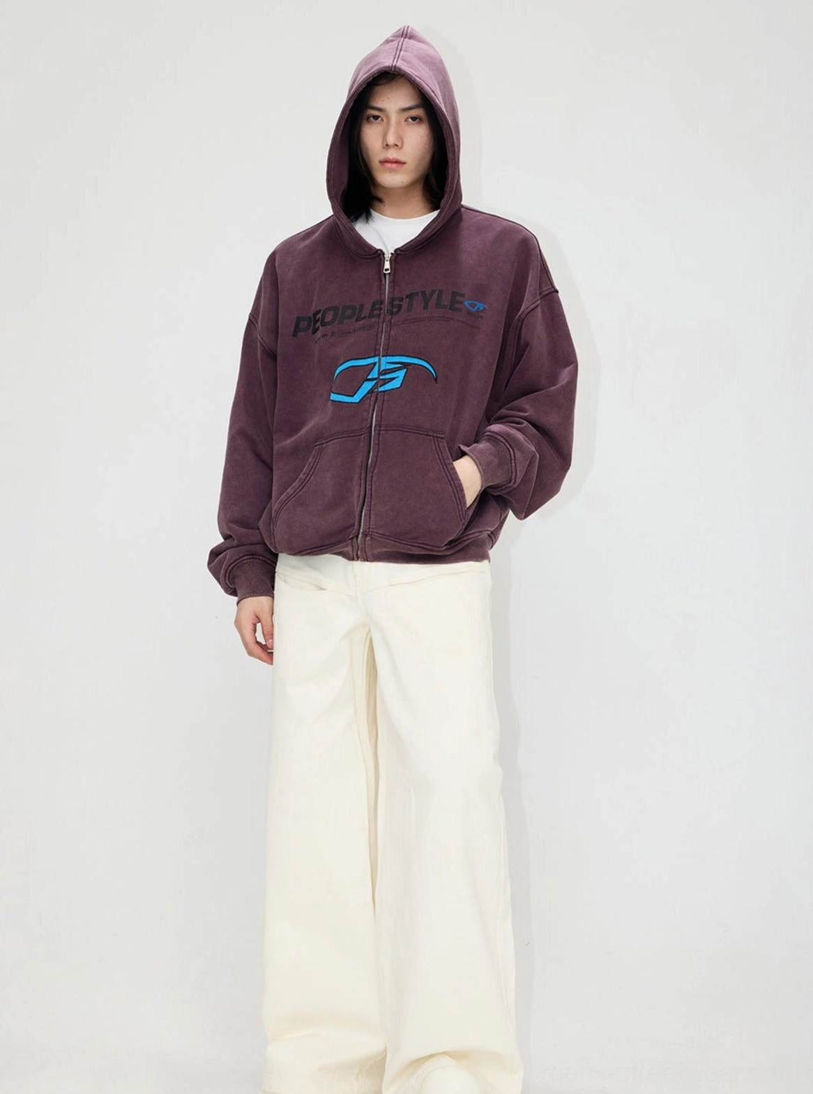 Dusty purple vintage distressed hooded streetwear jacket worn with hood up, full zipper, graphic prints, and white wide-leg pants