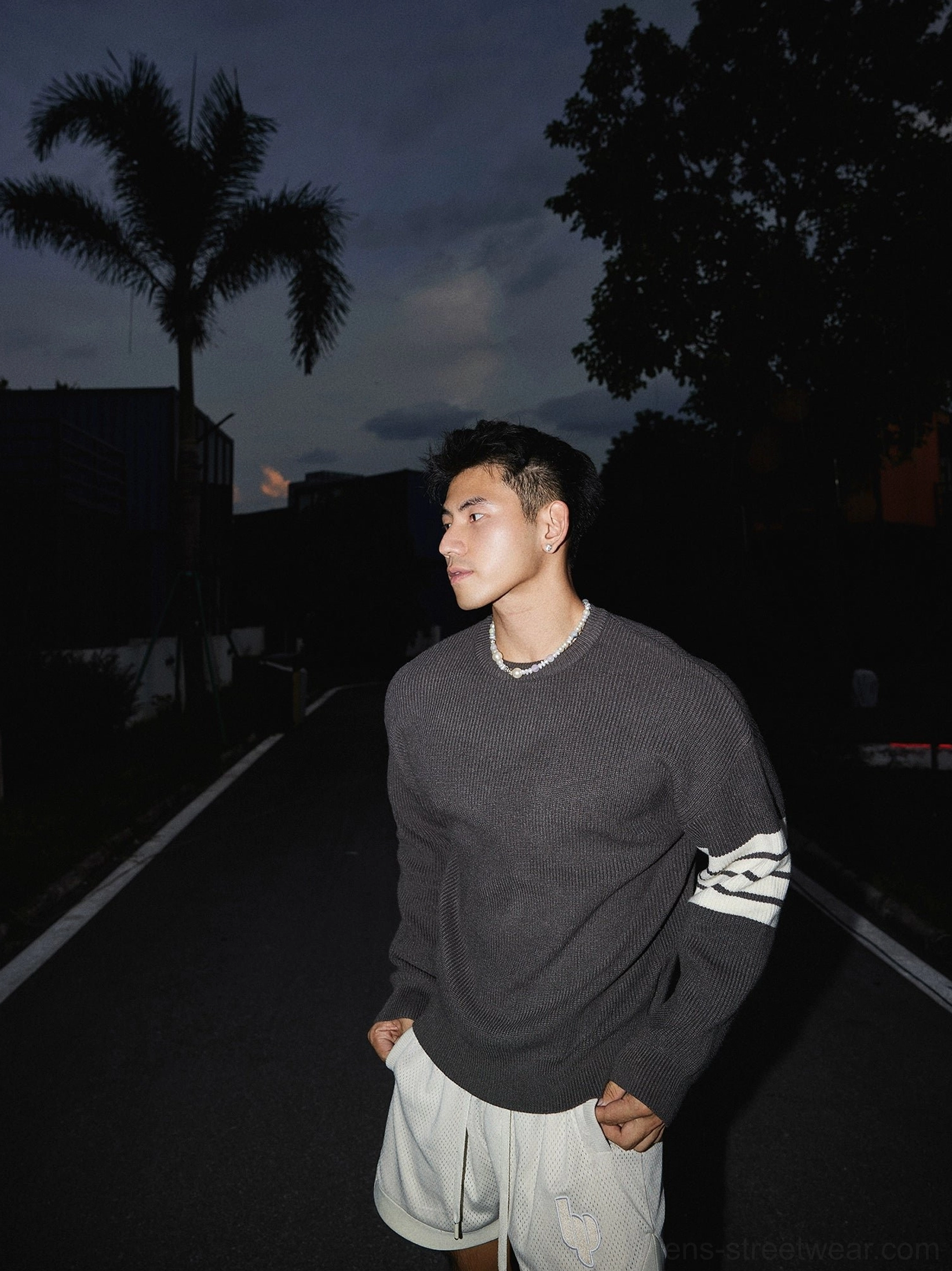 Contemporary East Asian fashion striped sleeve crewneck sweater with ribbed knit texture, loose fit, and casual Seoul streetwear aesthetic