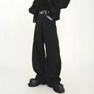 Black ultra wide-leg high-rise streetwear trousers shown from a low rear three-quarter angle with black leather boots in a white studio