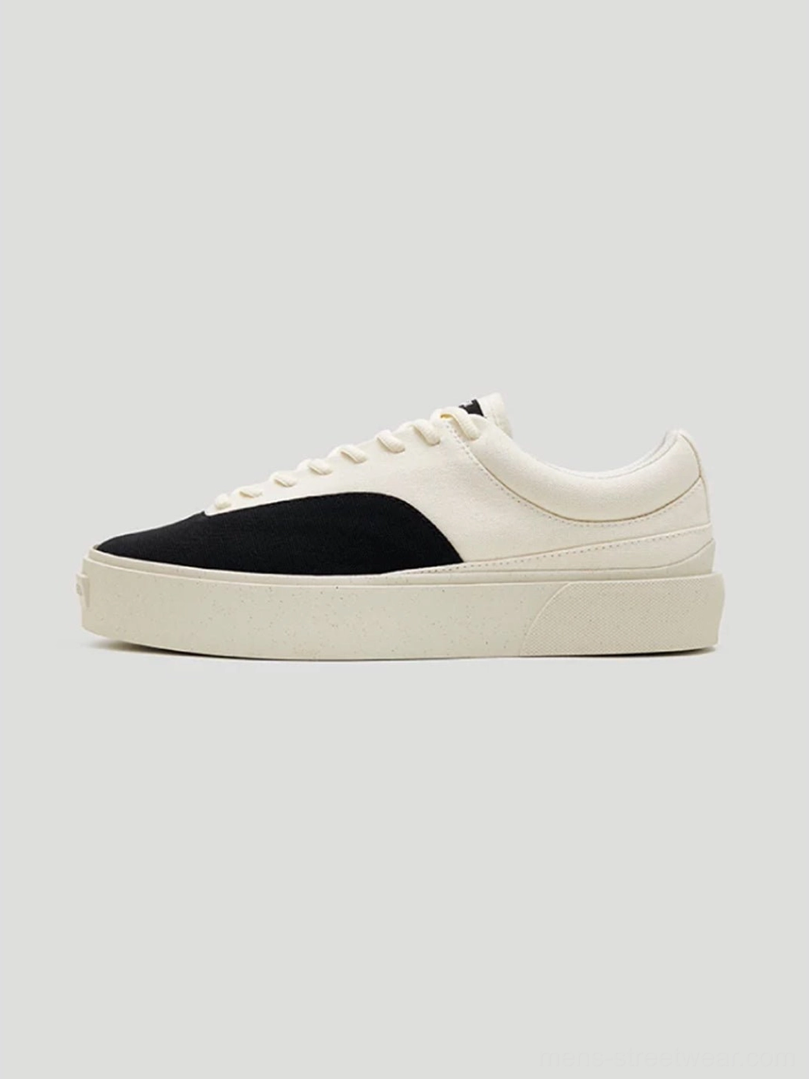 Side profile of streamlined low-top two-tone platform canvas skate shoes in egret white and black