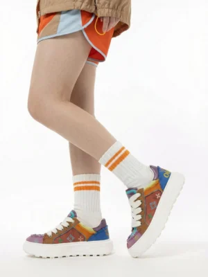 Model wearing multicolor platform skate sneakers with orange contrast shorts cropped streetwear jacket and striped crew socks in a low angle Seoul street style outfit