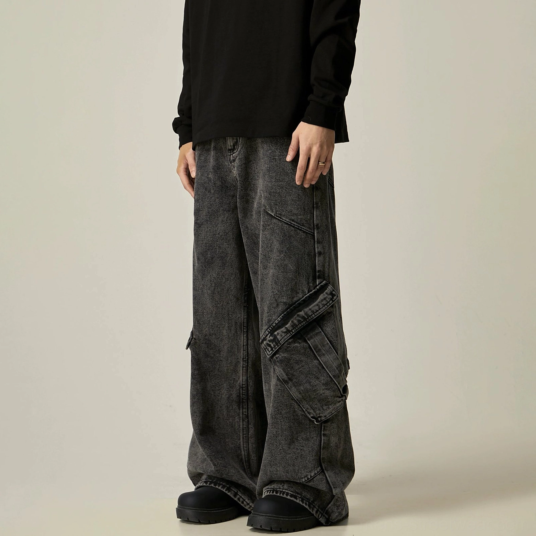 Right rear side view of faded black cargo wide jeans with a visible flap pocket, relaxed wide leg, and stacked streetwear length