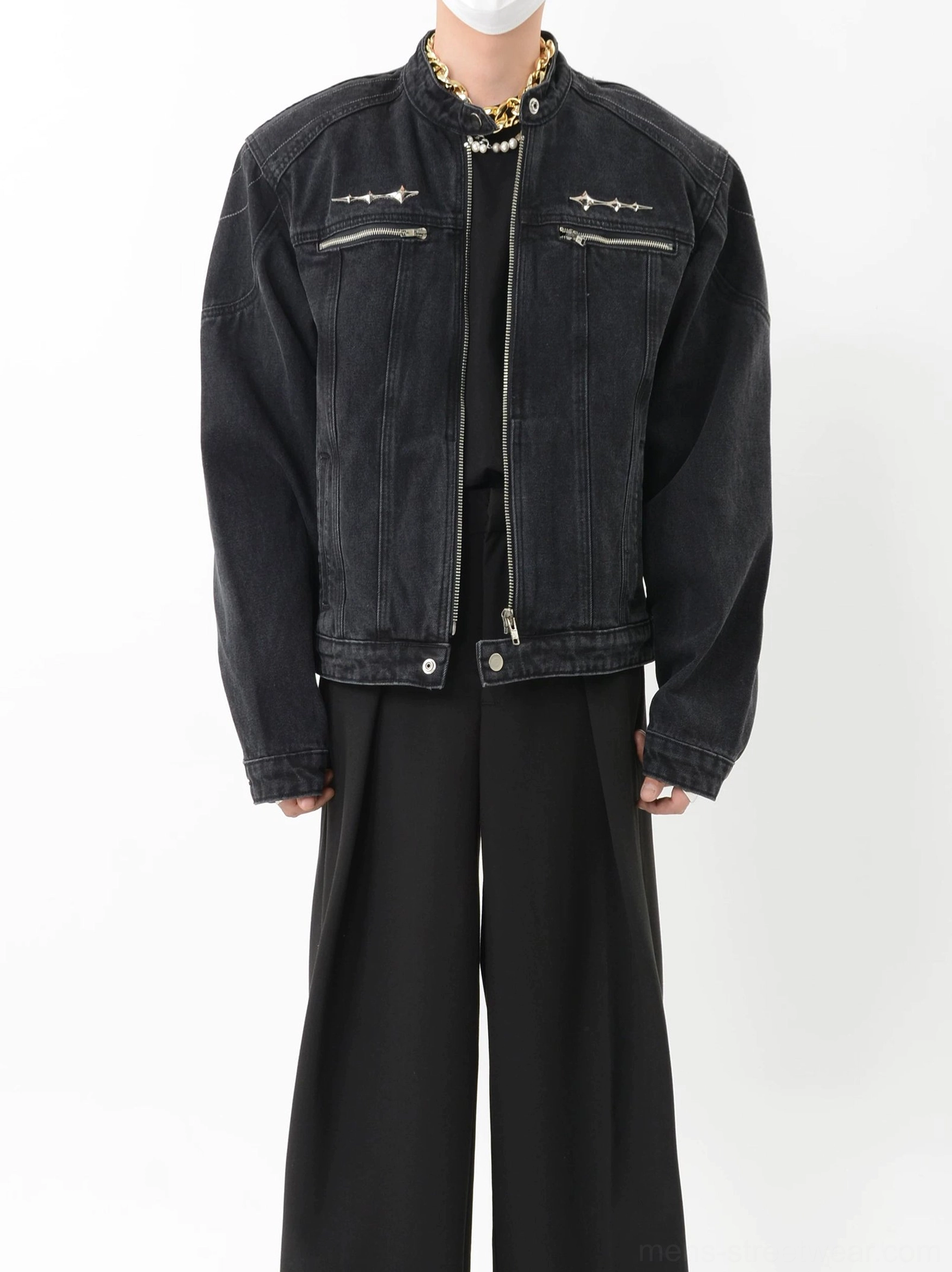 Front three quarter view of faded black denim moto jacket showing exposed front zipper dual chest zip pockets and stand collar