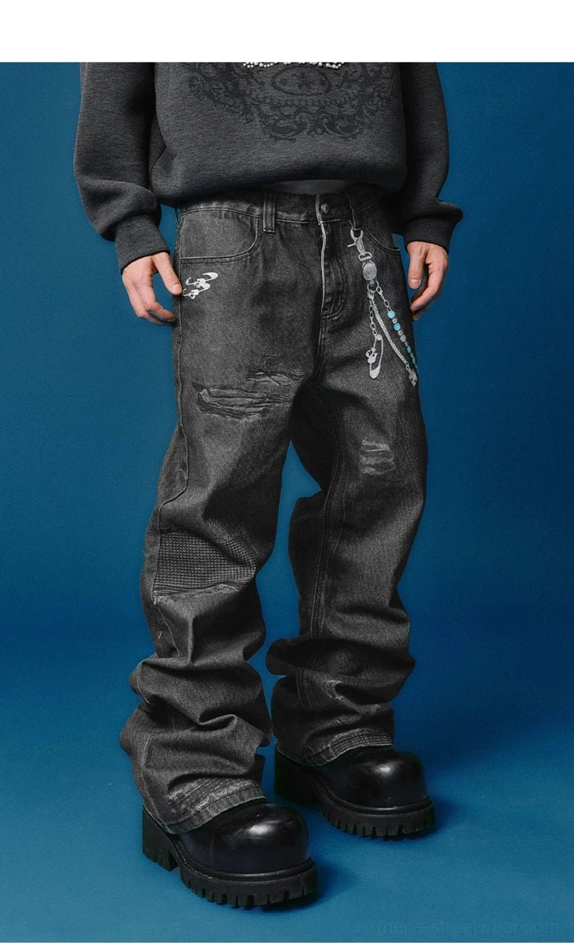 Front styling view of faded black distressed wide-leg jeans with extensive worn patches, gray sweatshirt, and chunky boots