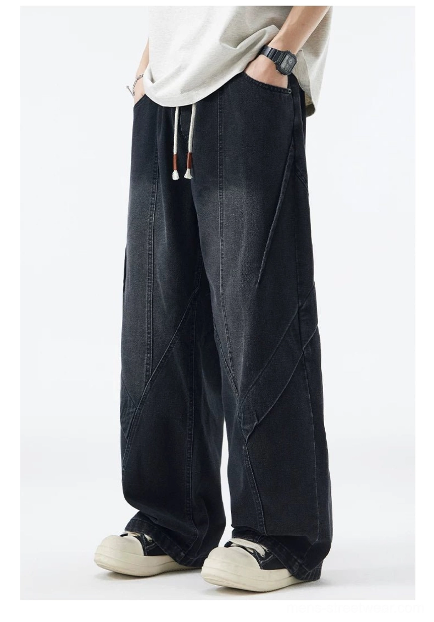 Faded black drawstring wide-leg jeans front three-quarter view with asymmetric denim panel stitching