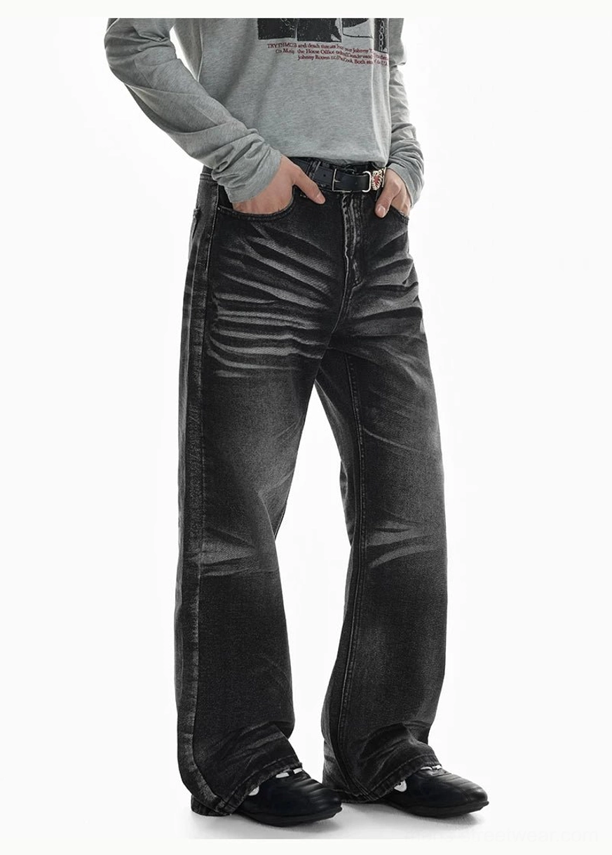 Left three-quarter view of faded black flare denim jeans with prominent whisker fading, tailored flared silhouette, belt loops, and soft stacking over black footwear