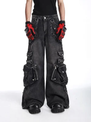 Front full-body view of faded black multi-pocket wide-leg cargo jeans styled with a black streetwear tee and red racing gloves, featuring oversized tactical pockets and a vintage washed finish