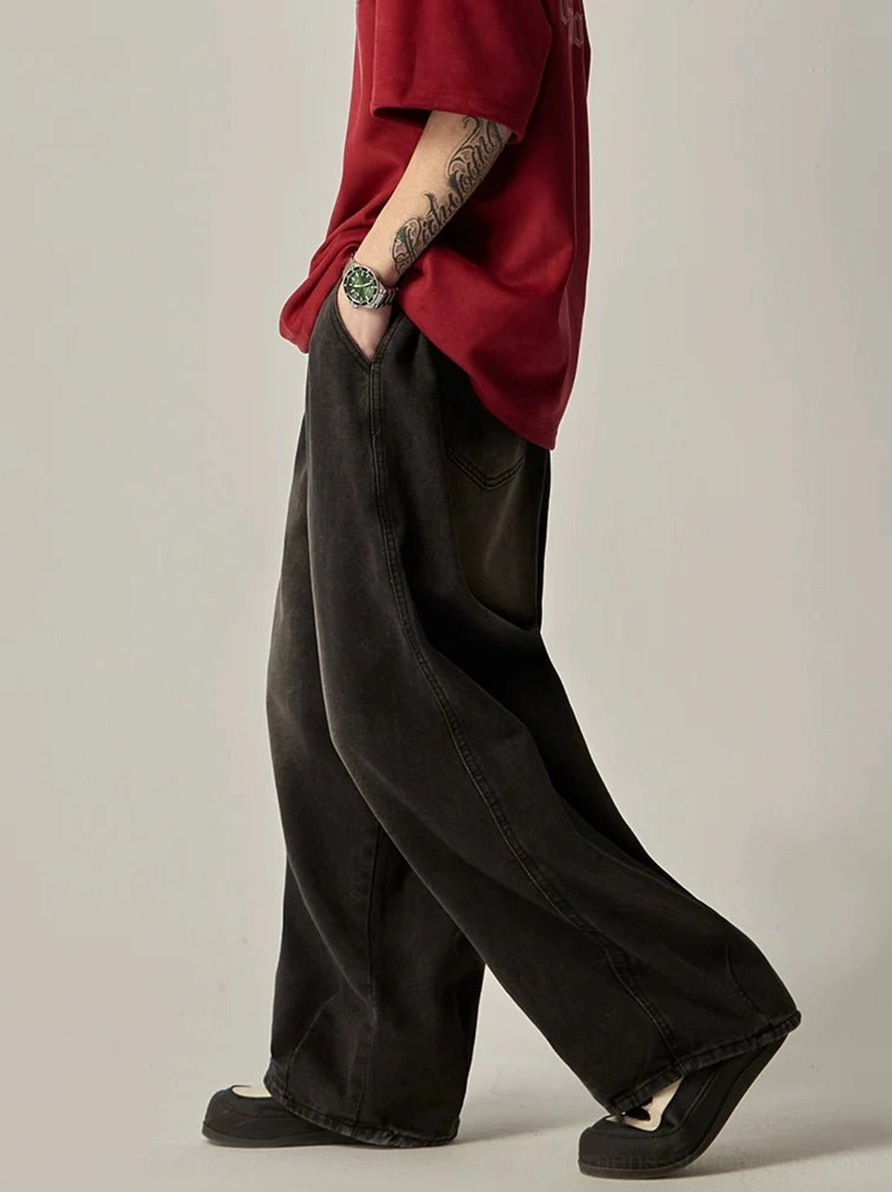 Walking side view of faded black relaxed wide-leg jeans with elastic waist and contemporary Seoul streetwear styling