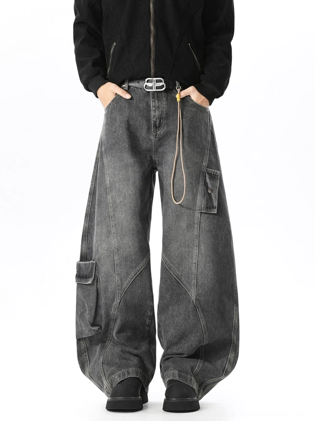 Faded black ultra-baggy cargo jeans styled with a black zip-up jacket, double-prong belt, waist rope detail, curved seams, and multiple utility pockets