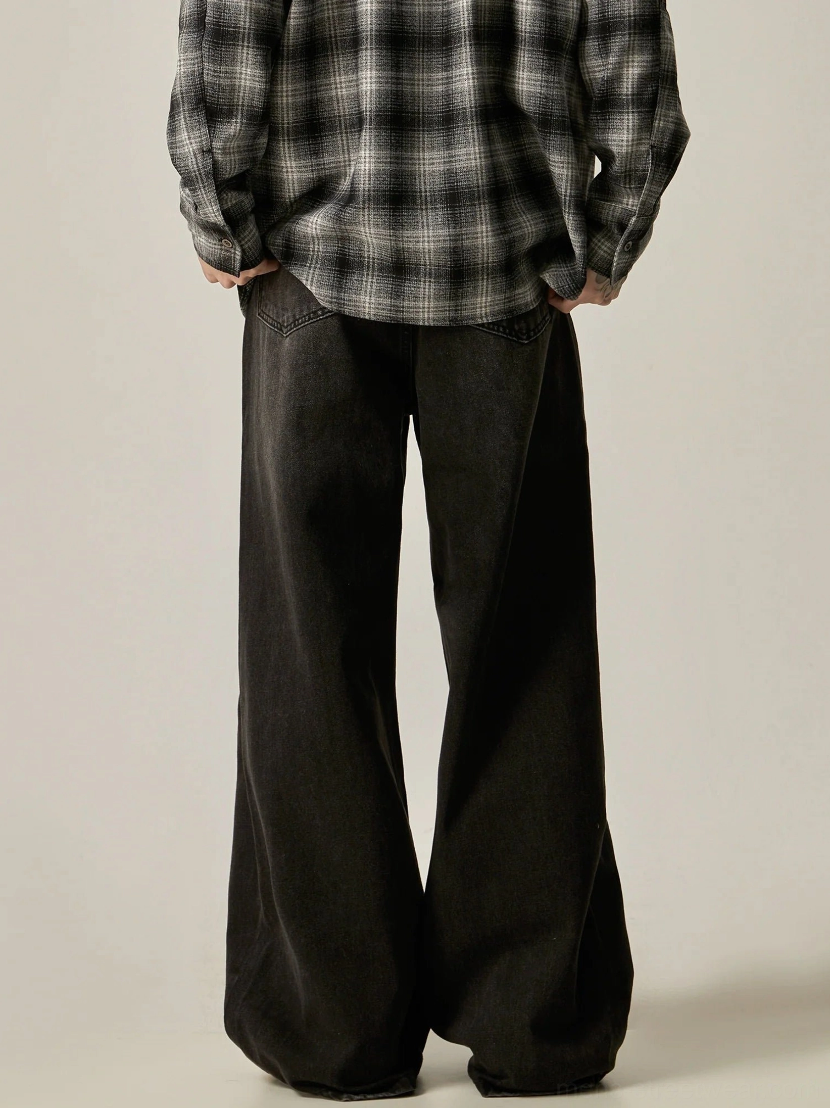 Rear view of faded black ultra-wide leg jeans showing classic back pockets and vintage wash texture