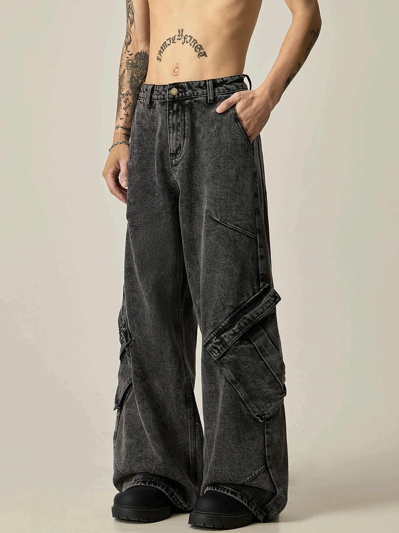 Right three-quarter view of faded black wide-leg cargo jeans with structured flap cargo pockets and relaxed streetwear fit