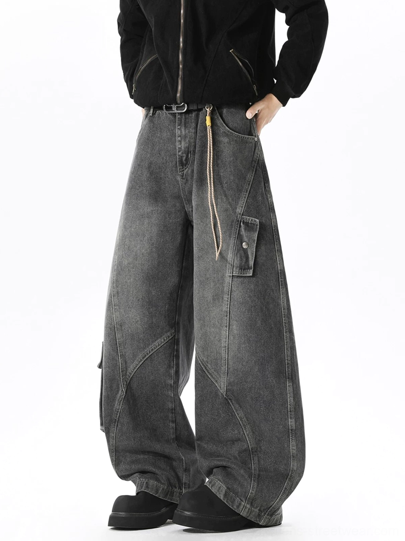 Faded black wide-leg cargo jeans shown from a side three-quarter view with snap-button utility pocket, waist rope decoration, curved seams, and loose fit