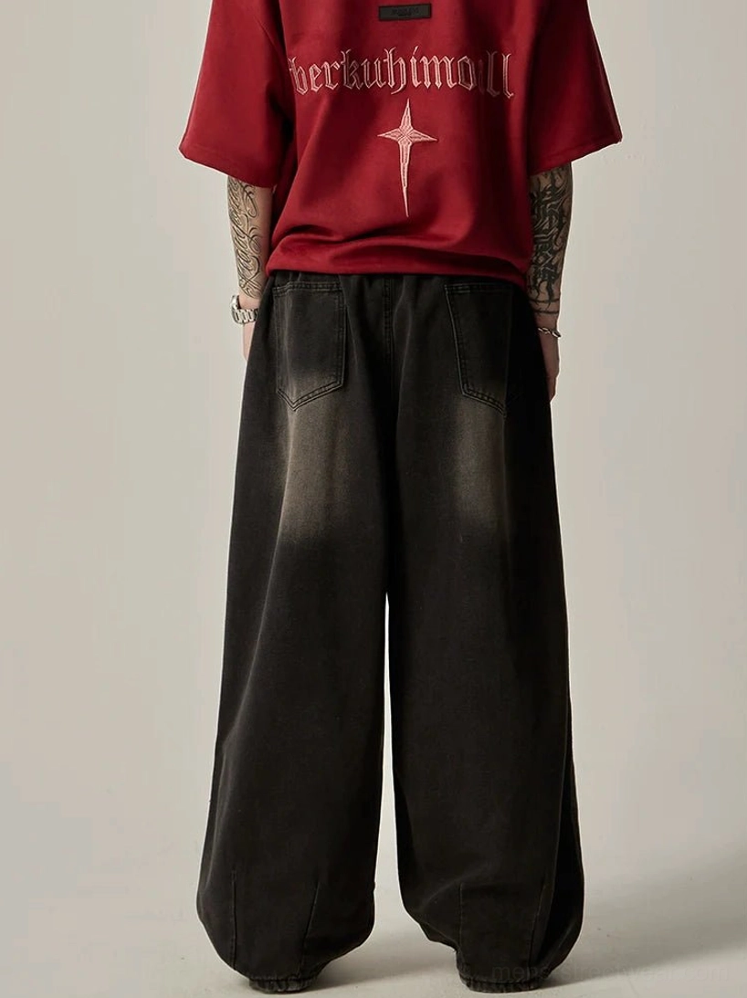 Back view of faded black wide-leg denim jeans with rear patch pockets and oversized relaxed streetwear silhouette