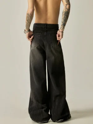 Rear view of faded black wide-leg denim jeans showing relaxed loose fit, classic back pockets, washed charcoal texture, and full-length streetwear silhouette