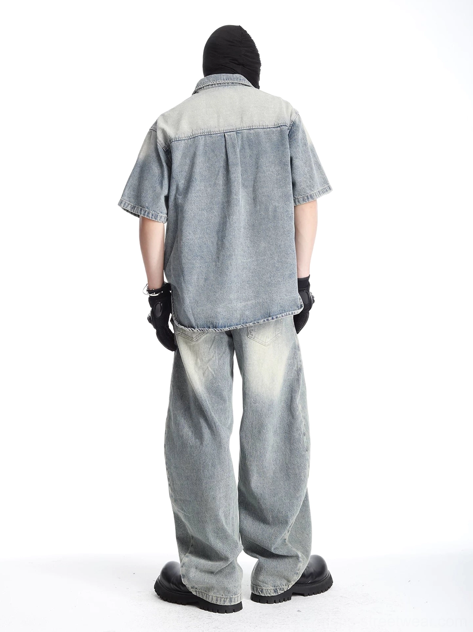 Rear view of faded blue denim shirt and matching wide-leg pants showing relaxed silhouette, back yoke seam, and vintage acid-wash finish