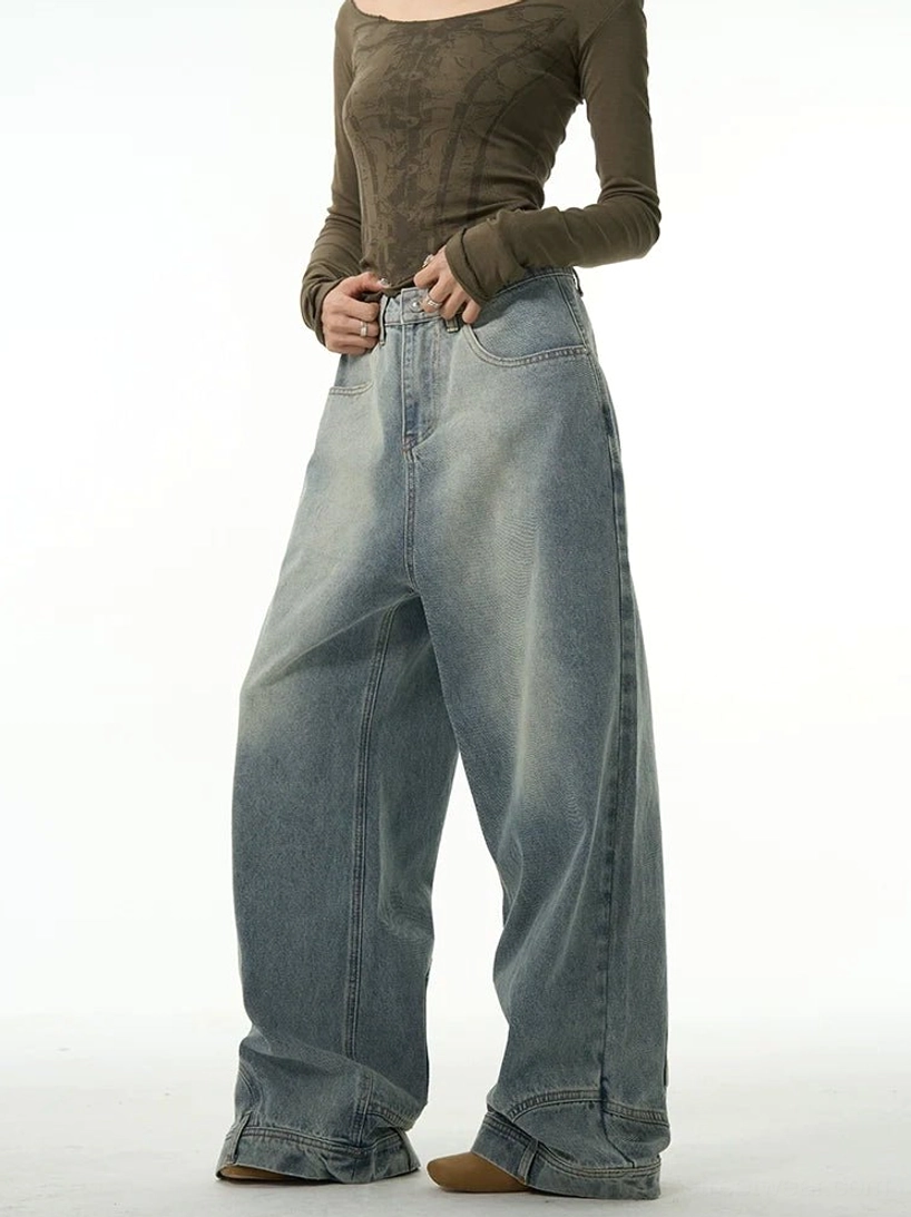 Left front view of faded blue inside-out wide-leg denim jeans with relaxed fit, layered rolled cuffs, and exposed construction details
