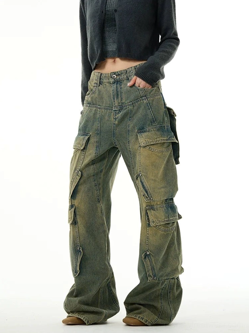 Three-quarter front view of faded blue multi-pocket cargo jeans with button closure, zip utility details, and relaxed wide-leg fit