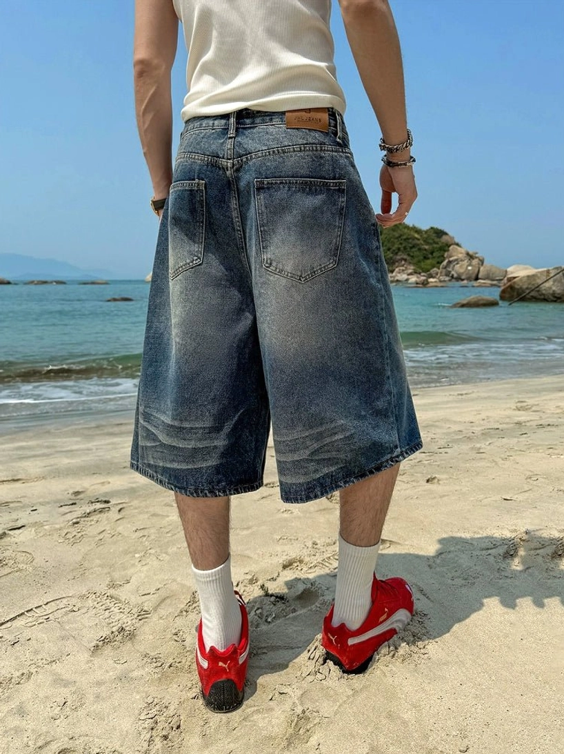 Rear view of faded blue oversized denim culotte shorts with wide-leg streetwear fit at the beach