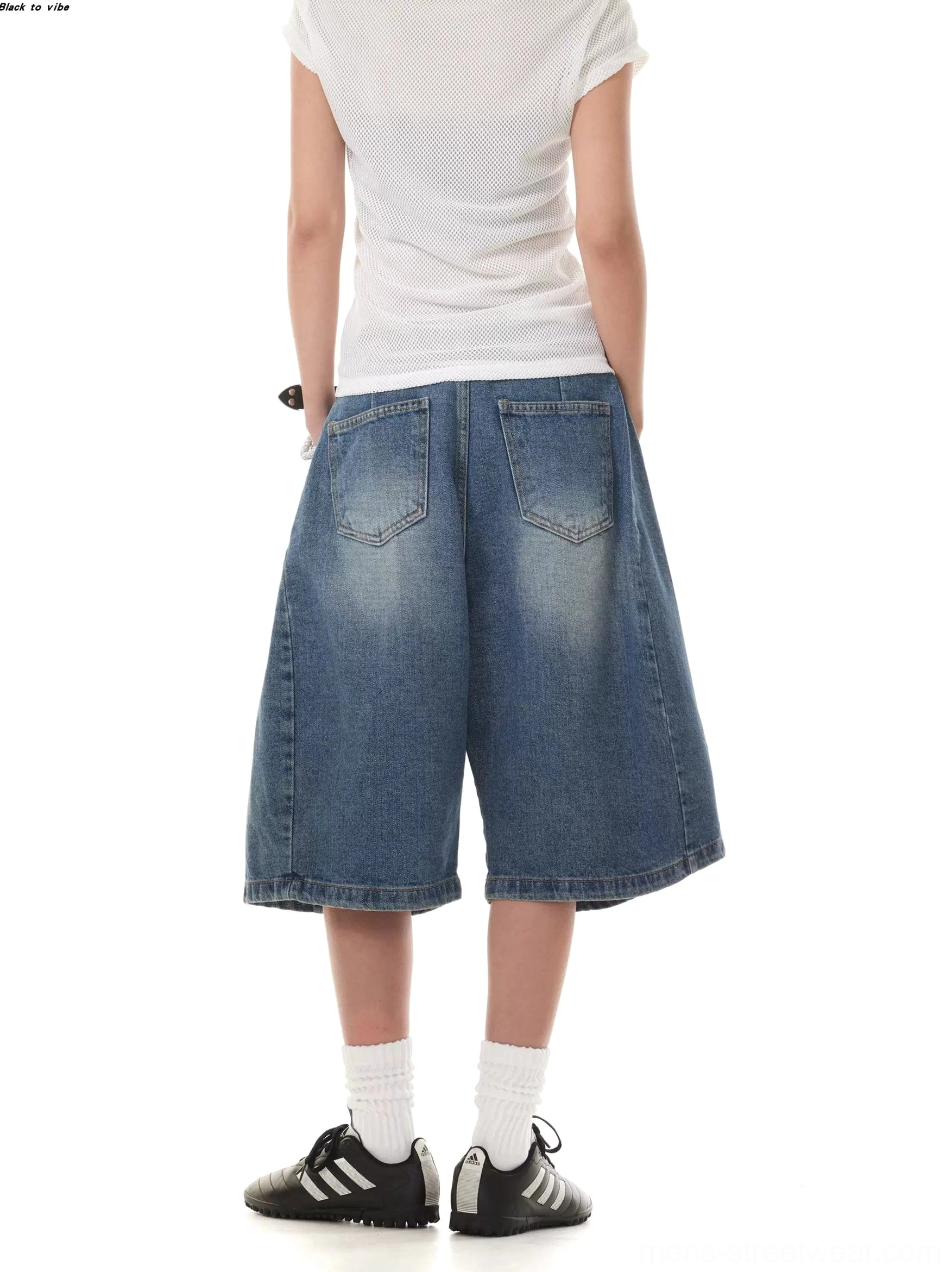 Rear view of faded blue wide-leg denim Bermuda shorts showing classic back pockets and relaxed streetwear fit