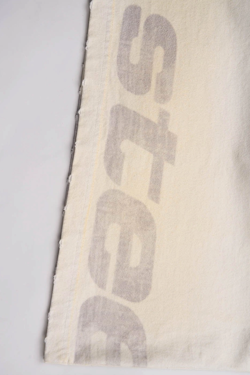 Faded cream vintage graphic T-shirt designed with bold gray graffiti lettering for modern men's streetwear outfits