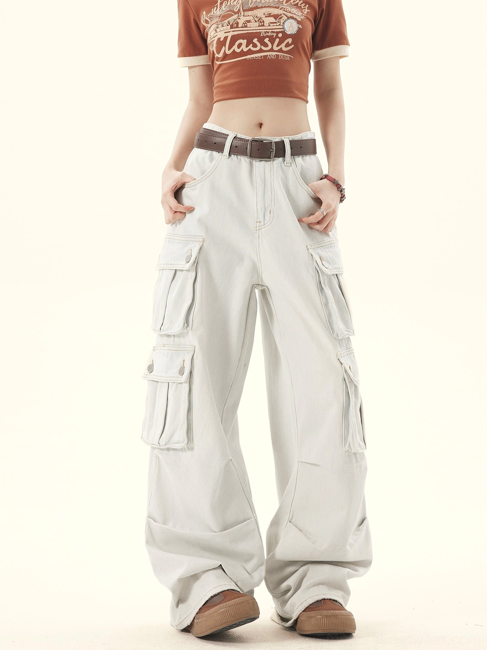 Front styling view of faded off-white wide-leg denim cargo trousers with utility flap pockets