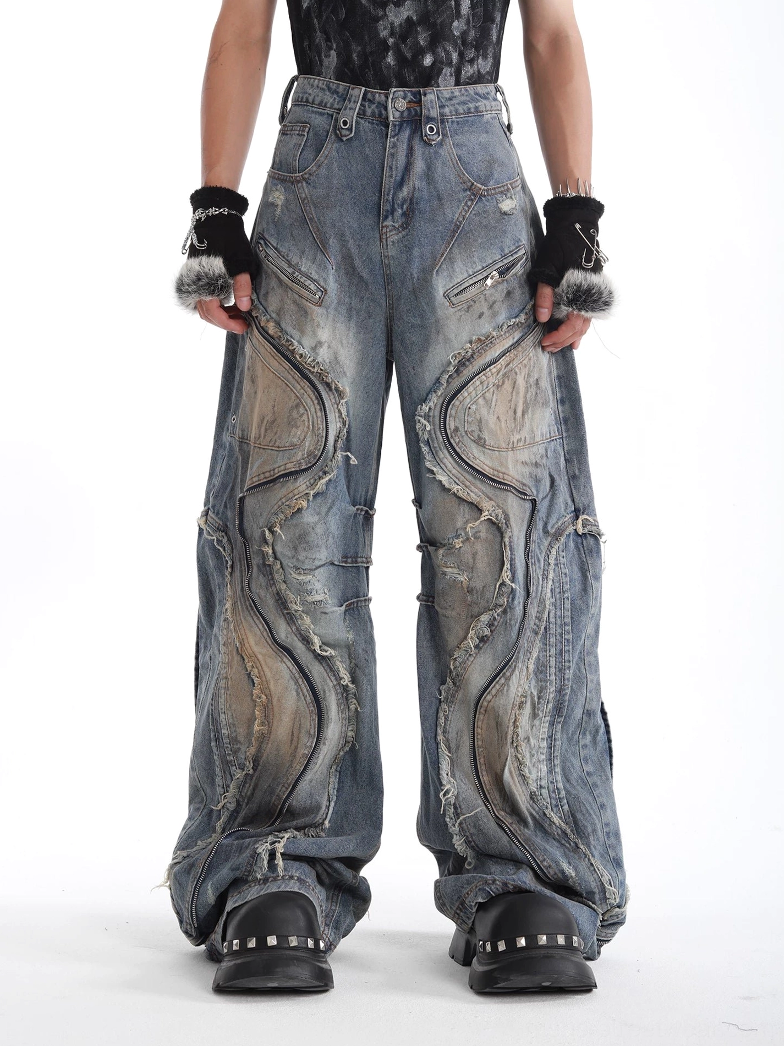 Front full-body view of faded blue deconstructed wide-leg denim jeans with curved raw-edge panels and vintage washed streetwear styling