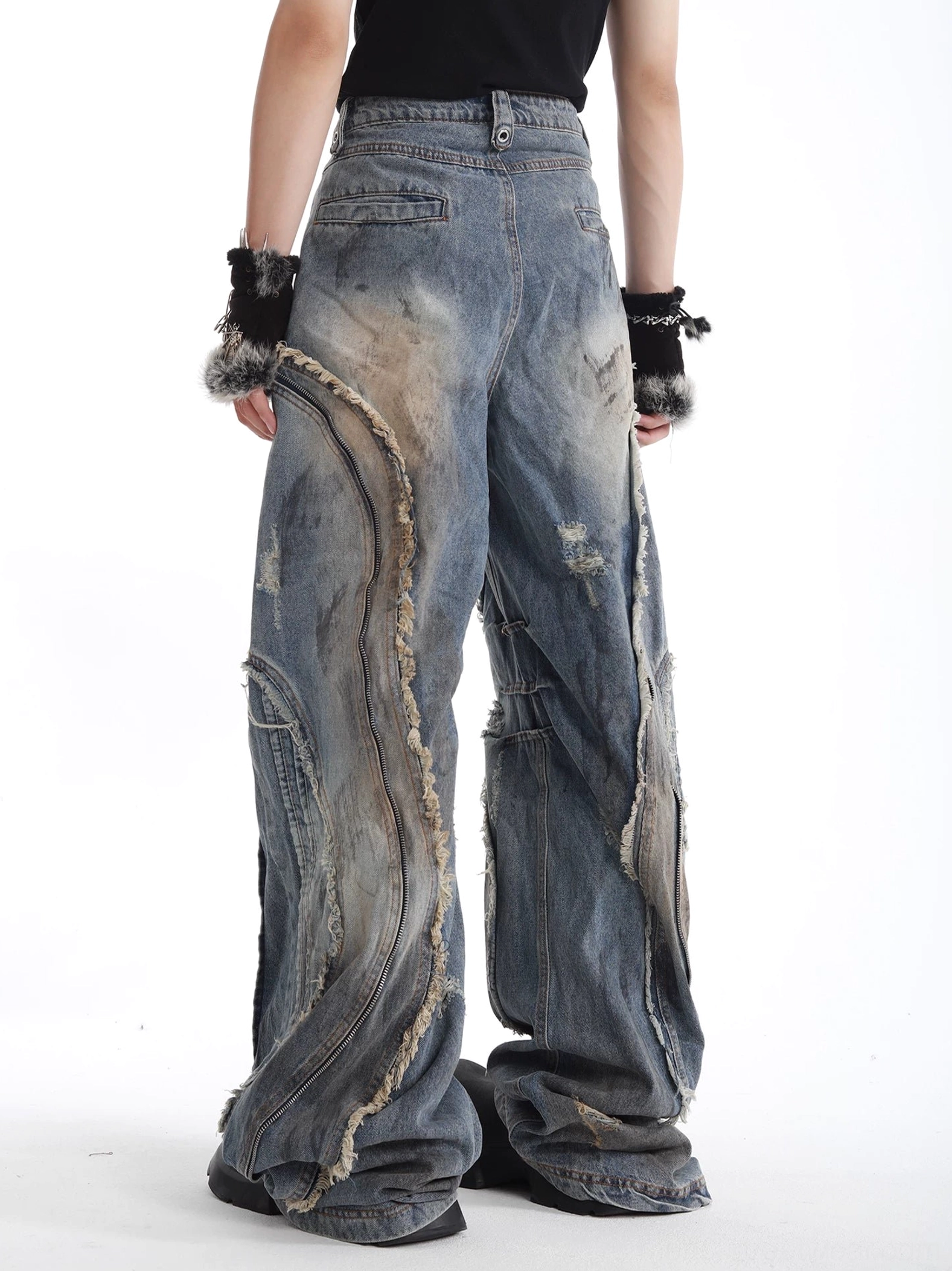 Back full-body view of deconstructed wide-leg denim jeans showing curved frayed rear panels classic back pocket and loose relaxed fit