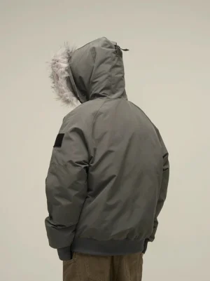Dark grey faux fur hooded puffer bomber jacket back view showing oversized fur-trim hood and sleeve patch