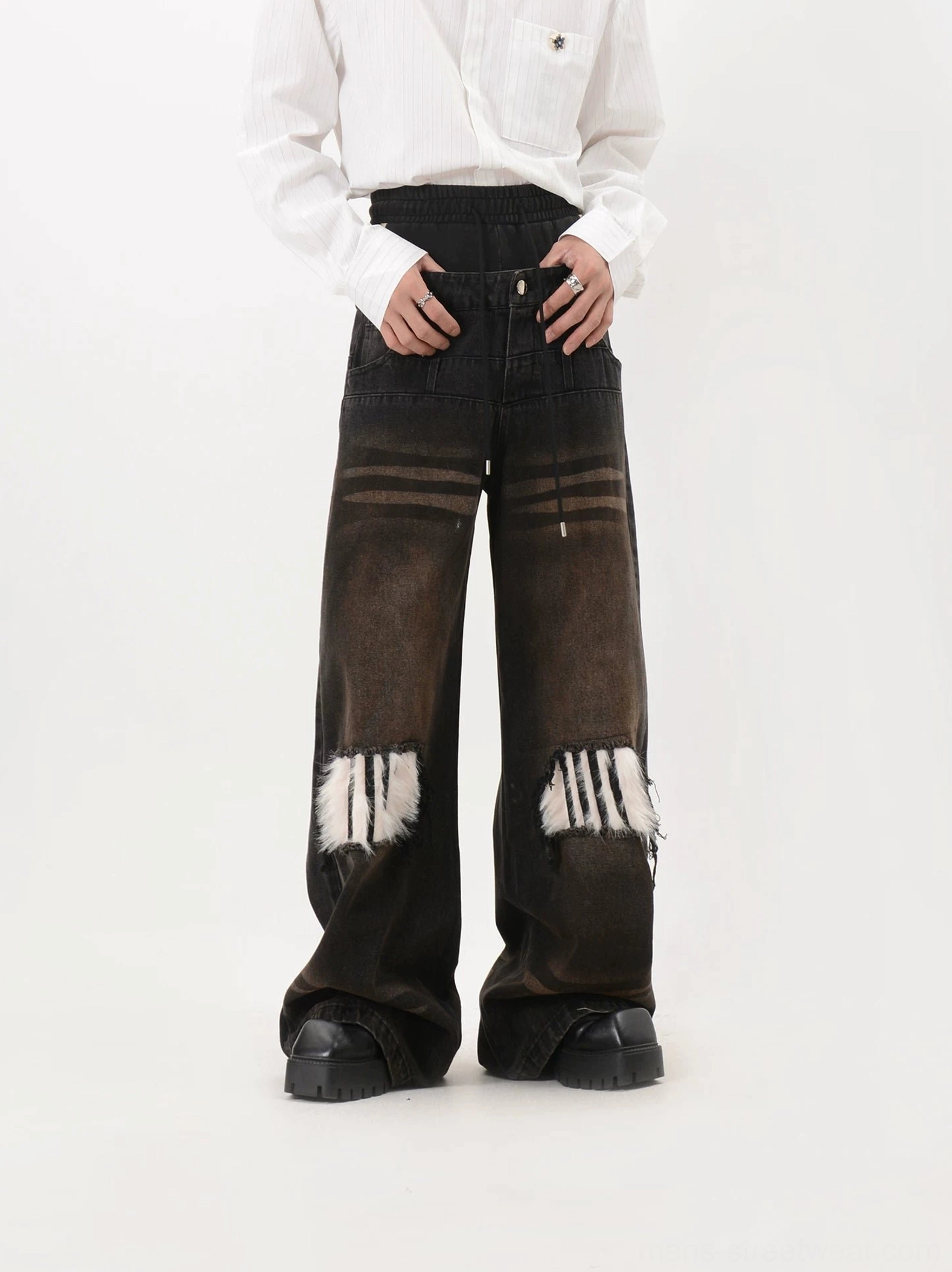 Close front view of faux fur knee patch jeans showing drawstring waistband, faded brown-black denim, distressed texture and layered streetwear construction